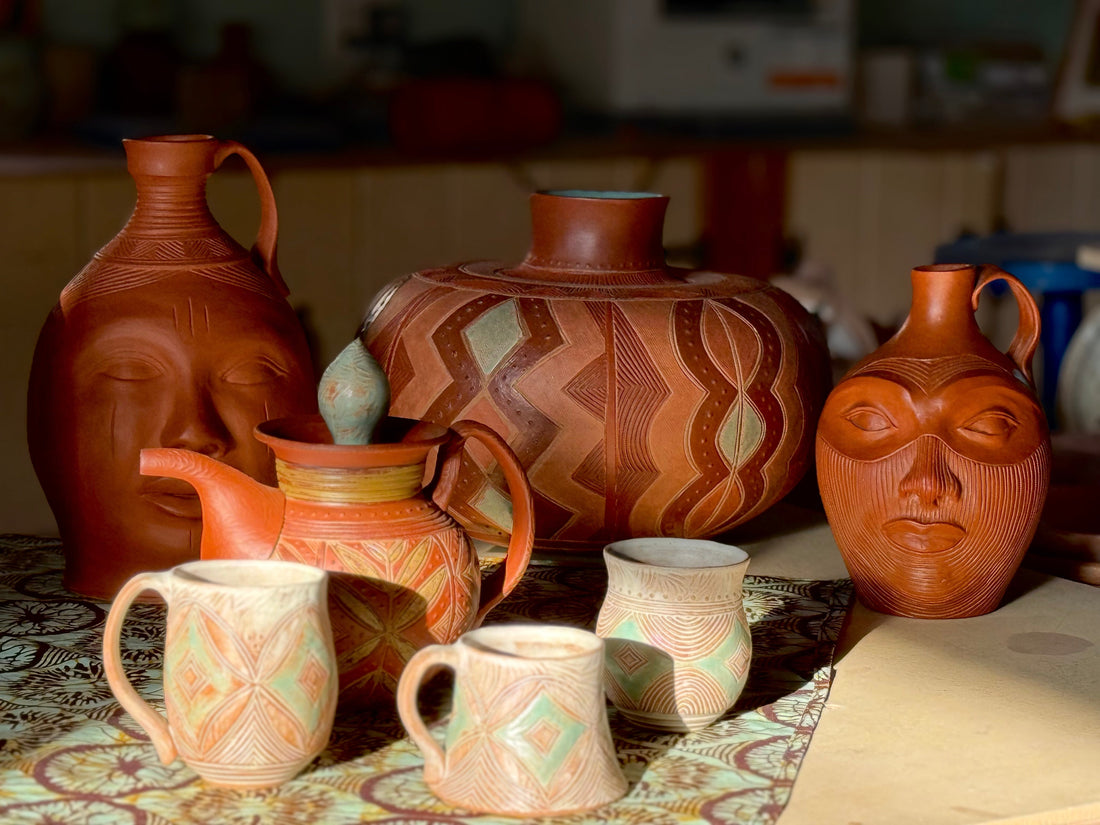 Current work - Pottery by Osa Atoe featuring various ceramic vessels, a teapot, two face jugs, a coil built pot and several mugs